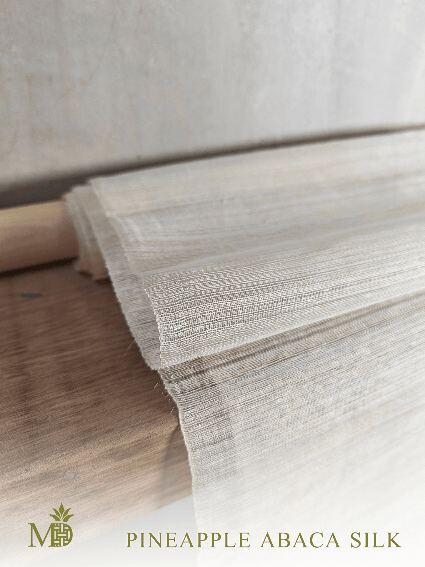 Close-up of Philippine natural pineapple abaca silk or pina abaca silk fabric on a wooden shelf by Manila Designer, handwoven sustainable textiles from the Philippines