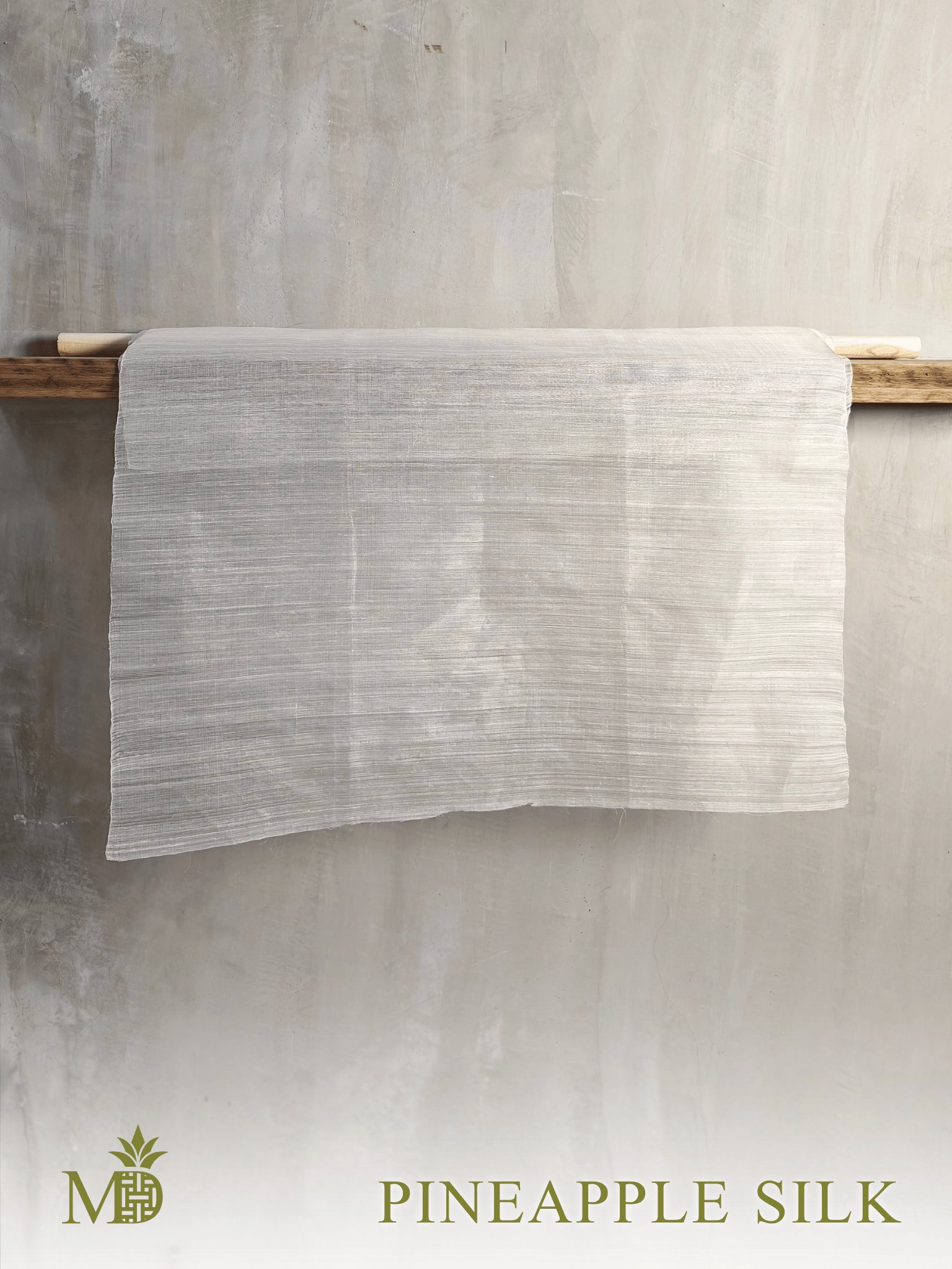 30" width Philippine natural Pineapple Silk or Pina Silk hanging on a wooden rod against a textured gray wall by Manila Designer, handwoven sustainable textiles from the Philippines